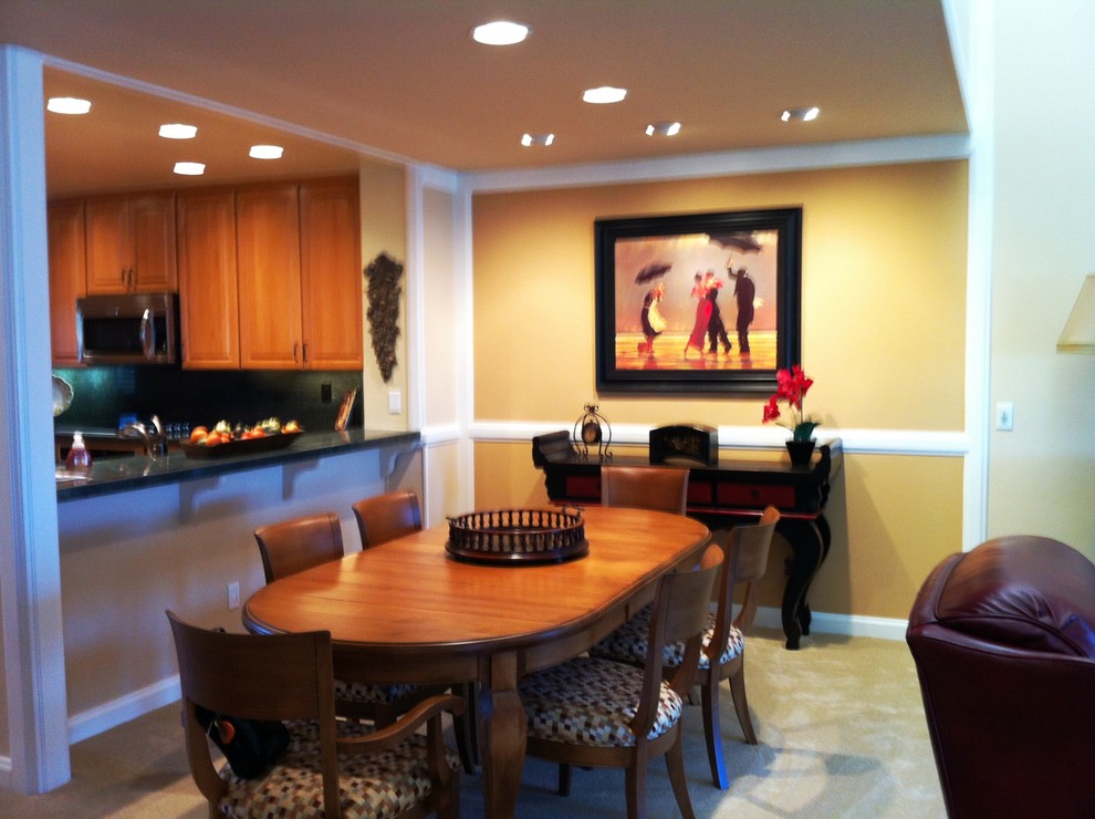 This is an example of a small classic open plan dining room in San Diego with beige walls and carpet.