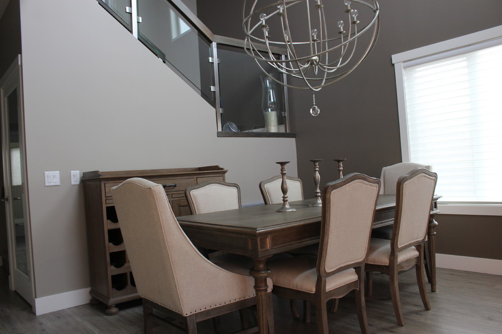 Exemple d'une salle à manger ouverte sur le salon chic de taille moyenne avec un mur gris, sol en stratifié, une cheminée ribbon, un manteau de cheminée en plâtre et un sol beige.
