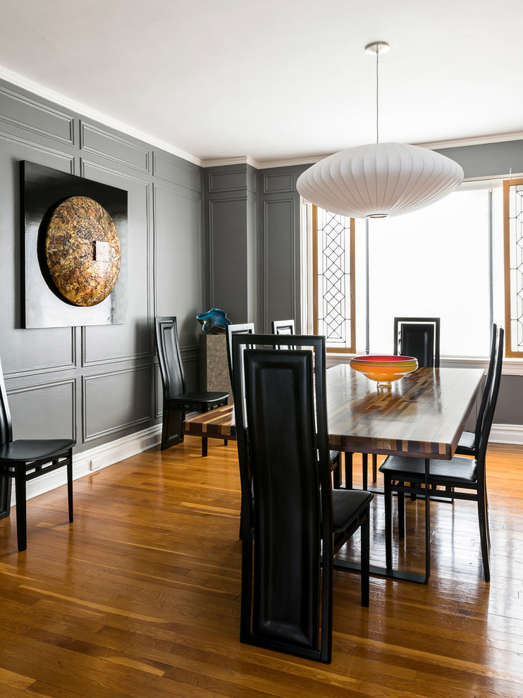 Ejemplo de comedor moderno grande cerrado con paredes grises, suelo de madera clara y suelo marrón