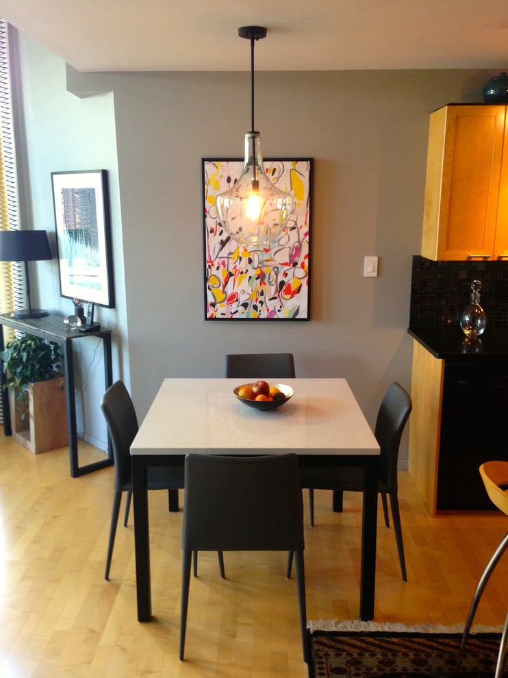 Exemple d'une petite salle à manger ouverte sur la cuisine éclectique avec un mur gris, parquet clair et aucune cheminée.