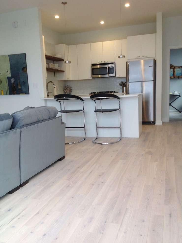 Kleine Moderne Wohnküche ohne Kamin mit weißer Wandfarbe und hellem Holzboden in Chicago