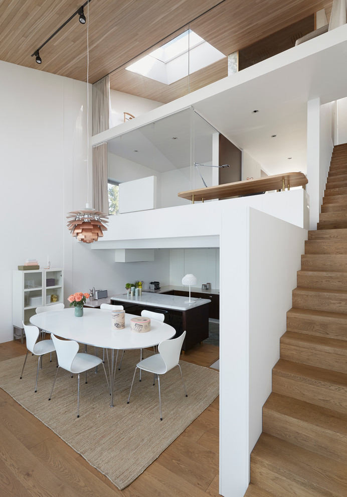 Große Nordische Wohnküche ohne Kamin mit weißer Wandfarbe und braunem Holzboden in Stockholm