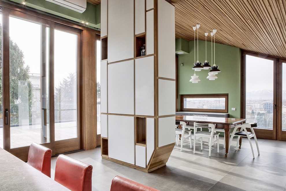 Immagine di una sala da pranzo design con pareti verdi e pavimento in cemento