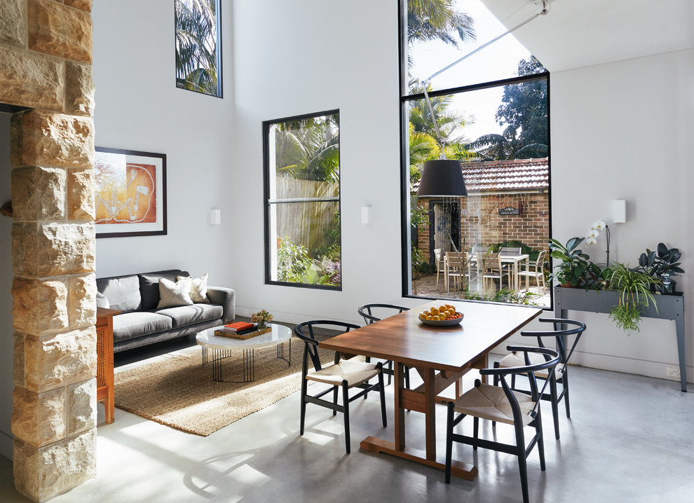 Design ideas for a contemporary open plan dining room in Sydney with white walls, concrete flooring and grey floors.
