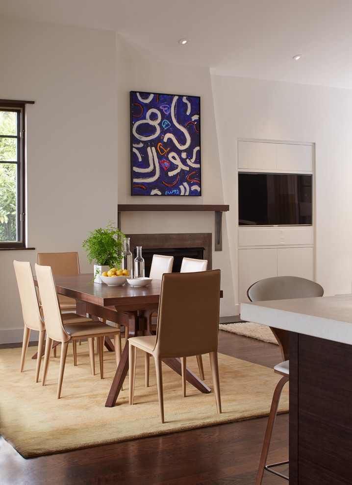 Ispirazione per una sala da pranzo aperta verso la cucina design di medie dimensioni con pareti bianche, pavimento in legno massello medio e camino classico
