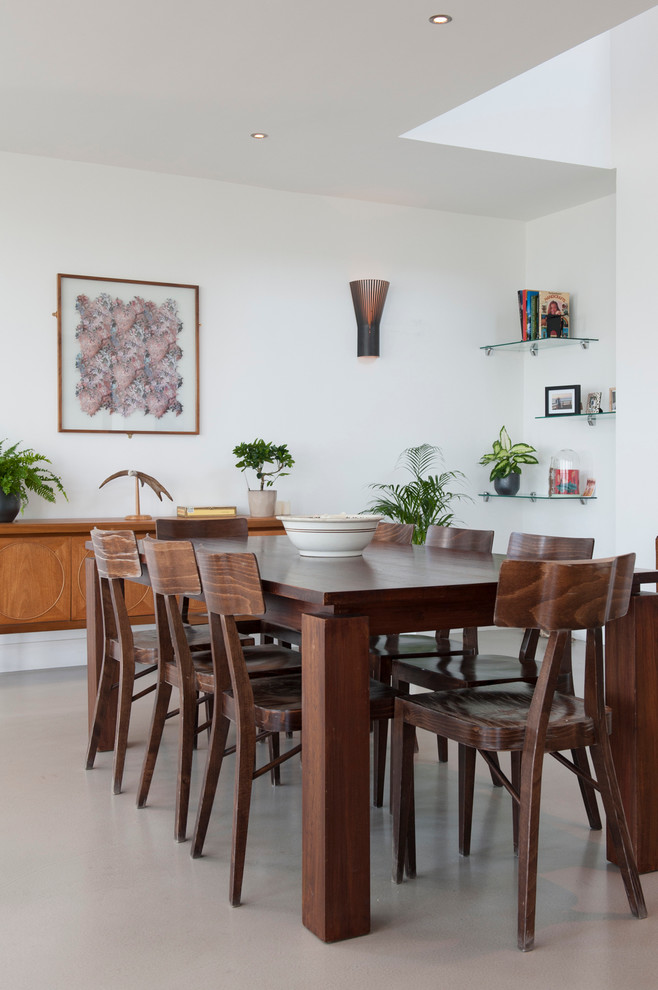This is an example of a contemporary dining room in Other with white walls, concrete flooring and grey floors.