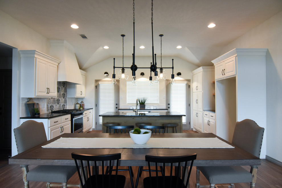 Foto di una sala da pranzo aperta verso la cucina minimal di medie dimensioni con pareti bianche, pavimento in vinile e pavimento marrone
