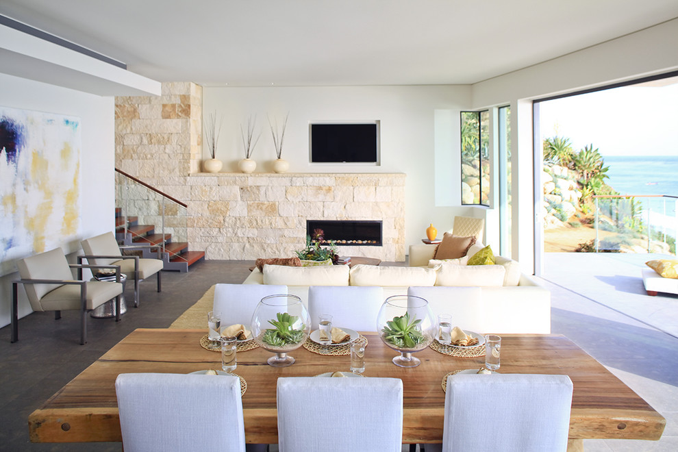 Contemporary open plan dining room in Orange County with a stone fireplace surround.