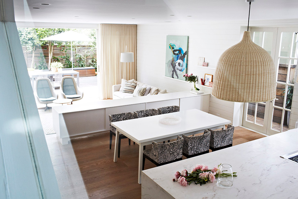 Aménagement d'une salle à manger ouverte sur la cuisine contemporaine avec un mur blanc et parquet foncé.