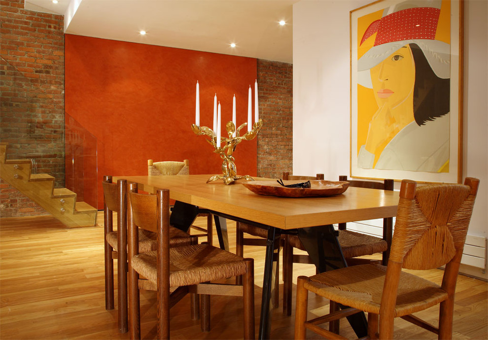 This is an example of a contemporary dining room in New York with white walls and medium hardwood flooring.