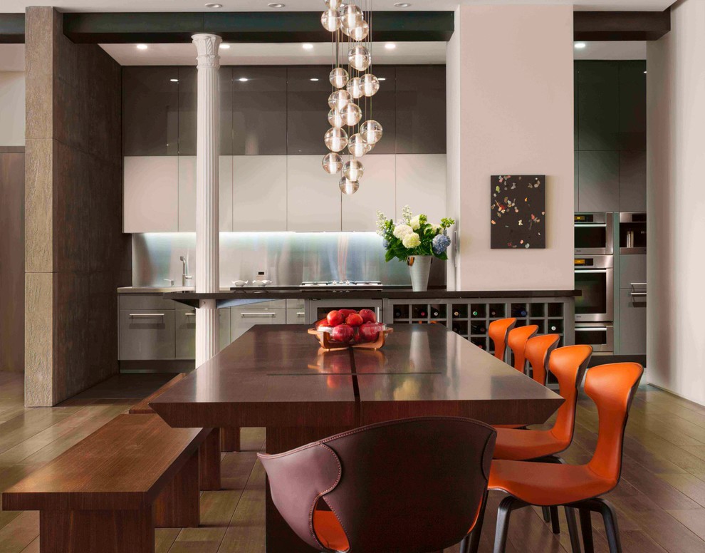 This is an example of a large contemporary kitchen/dining room in New York with white walls and light hardwood flooring.