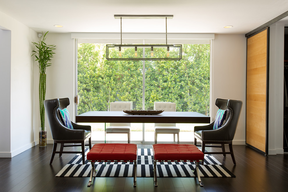 Photo of a large contemporary dining room in Los Angeles with white walls, dark hardwood flooring and black floors.