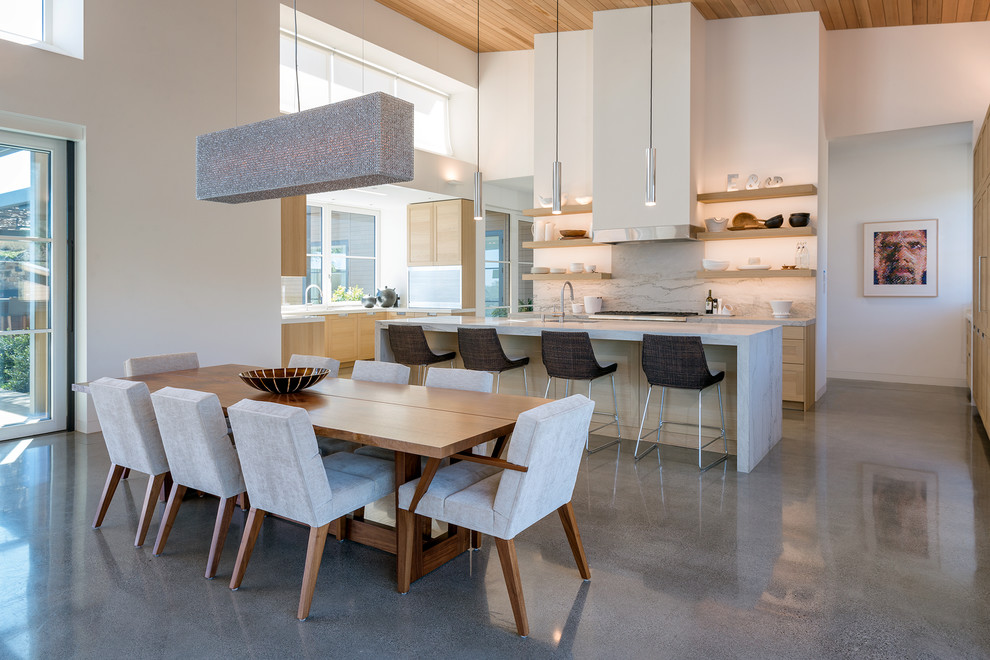 Idee per una sala da pranzo aperta verso il soggiorno minimal con pareti bianche e pavimento grigio