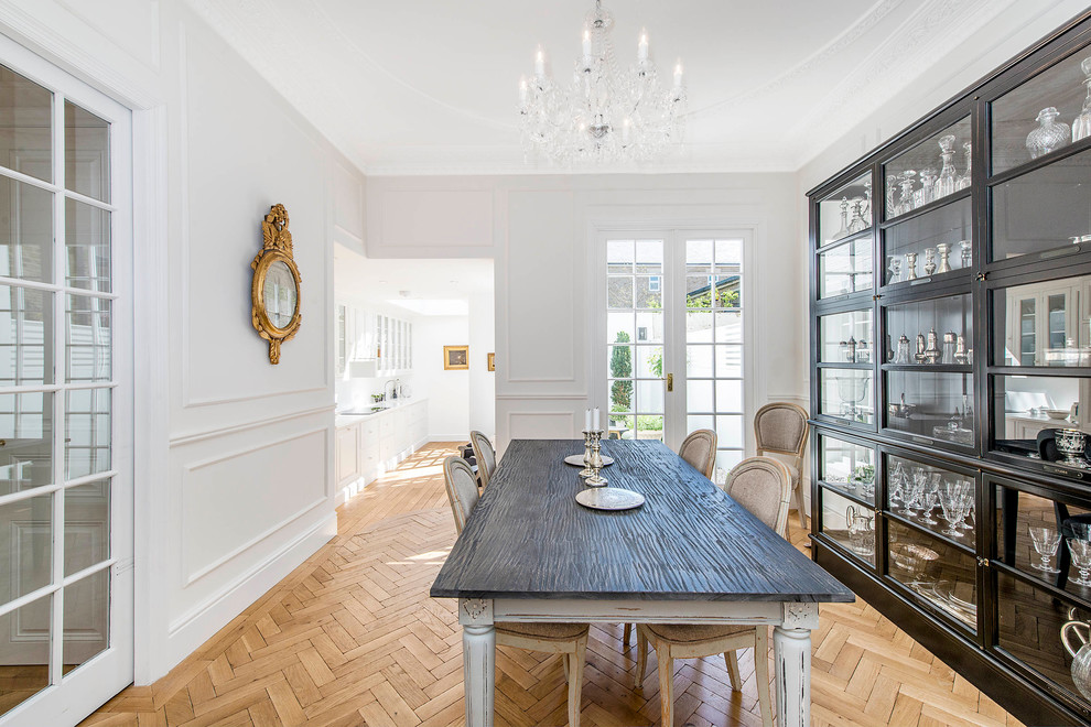 Medium sized contemporary dining room in London with white walls and light hardwood flooring.
