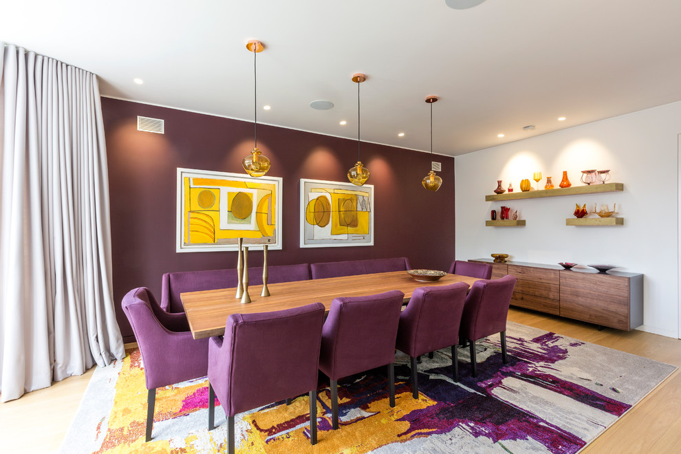 Contemporary dining room in London with purple walls, light hardwood flooring and beige floors.
