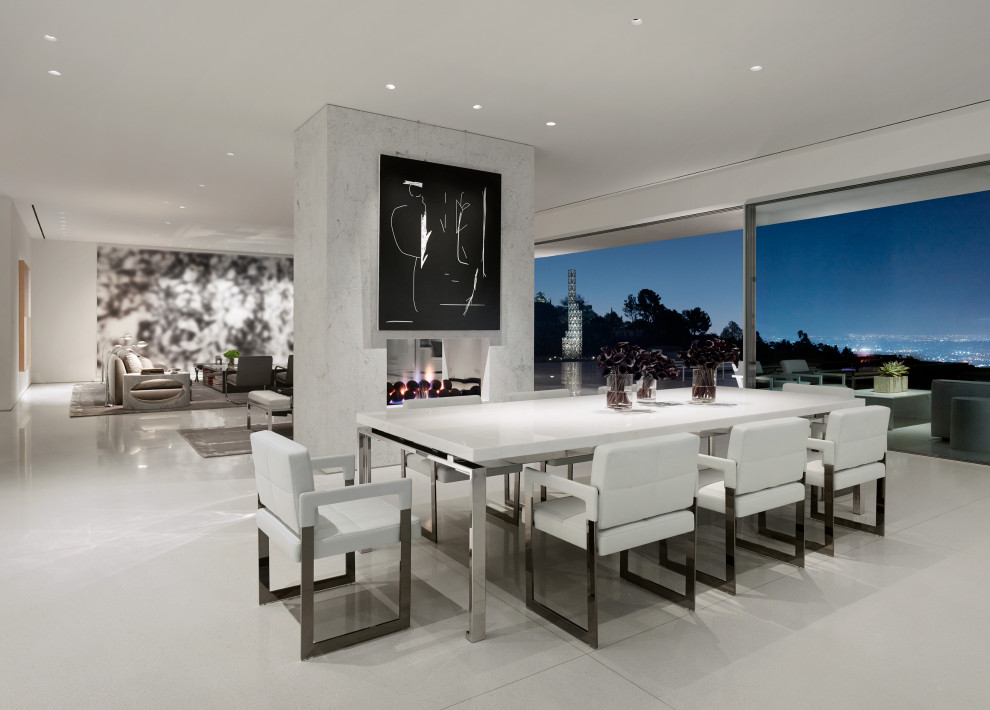 На фото: огромная гостиная-столовая в современном стиле с серыми стенами, двусторонним камином, фасадом камина из плитки и серым полом