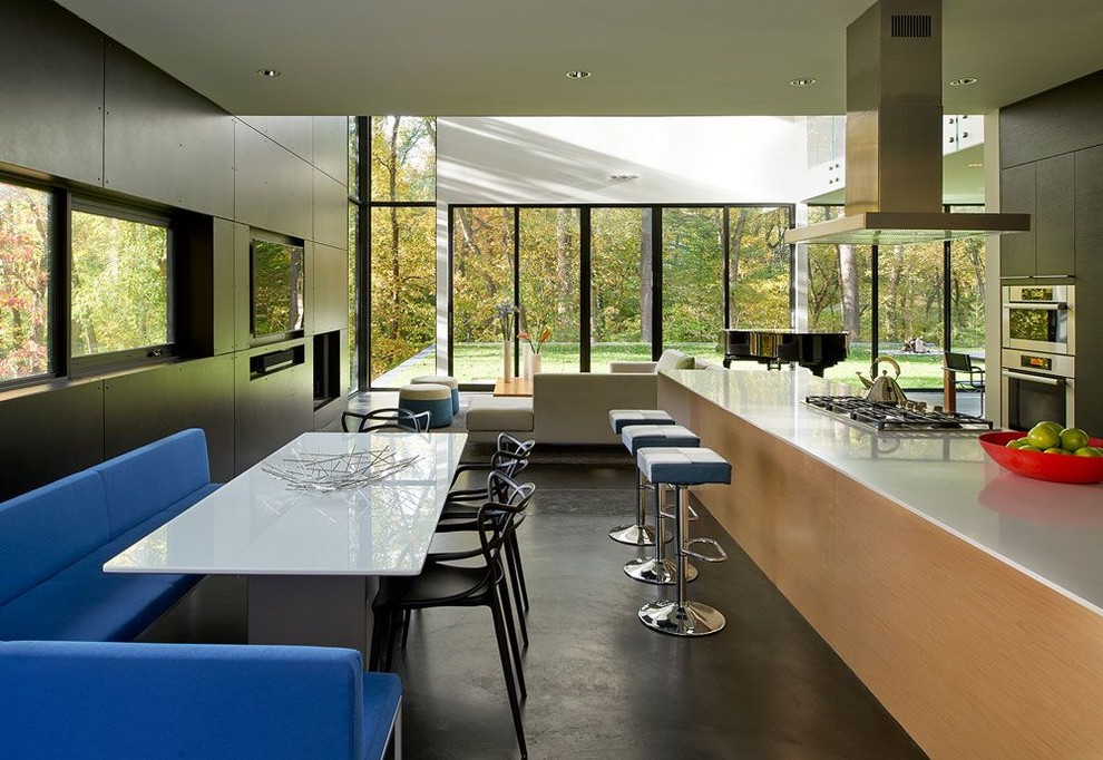 На фото: гостиная-столовая в современном стиле с бетонным полом с