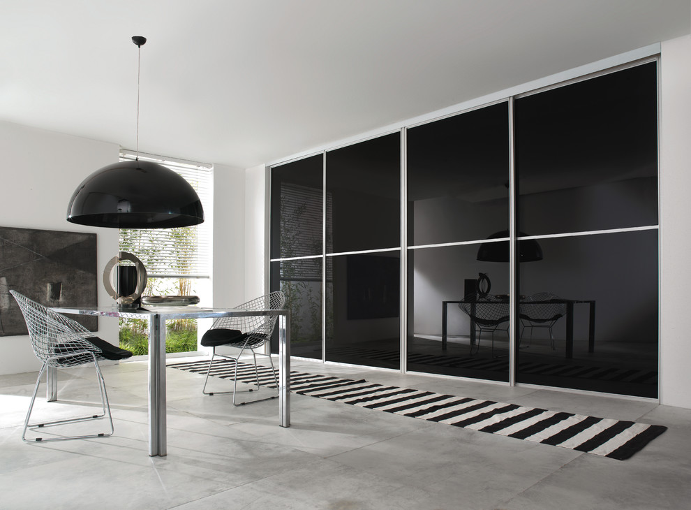 Стильный дизайн: столовая в современном стиле с бетонным полом и белыми стенами - последний тренд