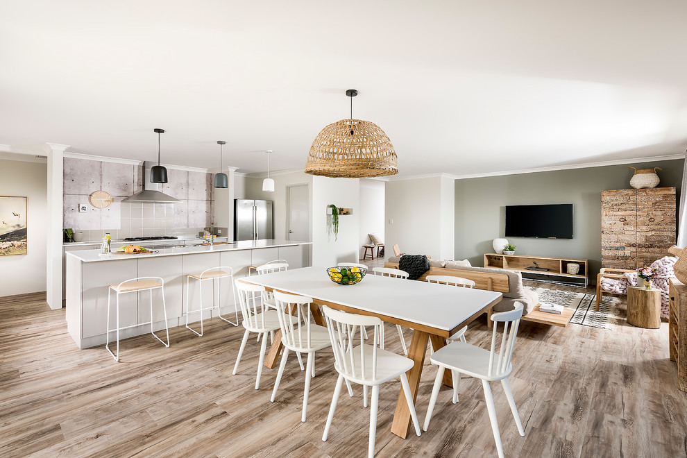 Cette image montre une salle à manger ouverte sur le salon design de taille moyenne avec un mur gris, sol en stratifié et un sol marron.