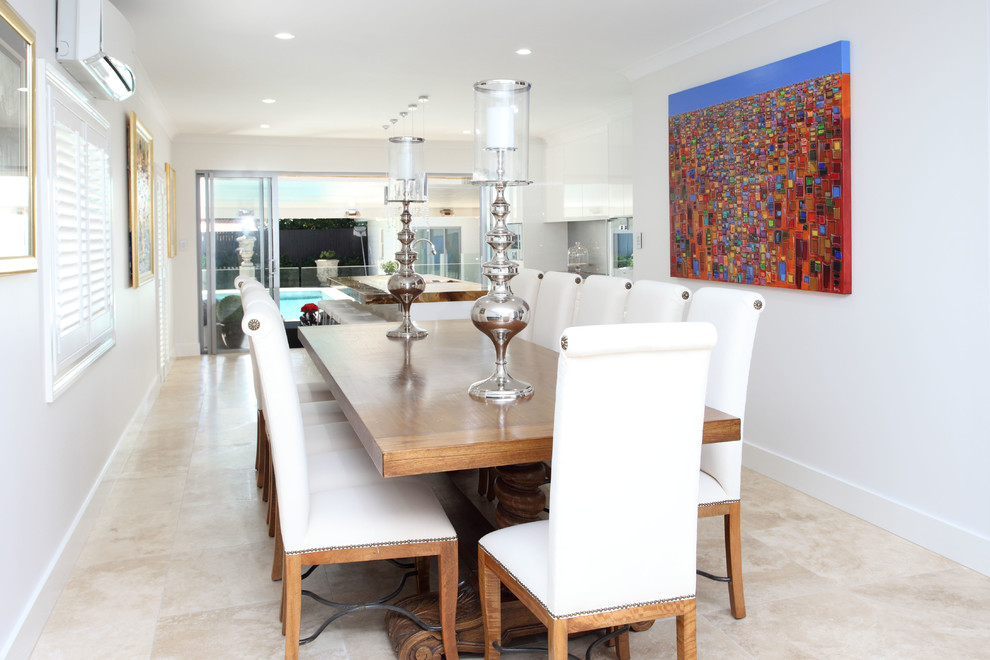 Immagine di una sala da pranzo aperta verso la cucina minimal con pareti bianche