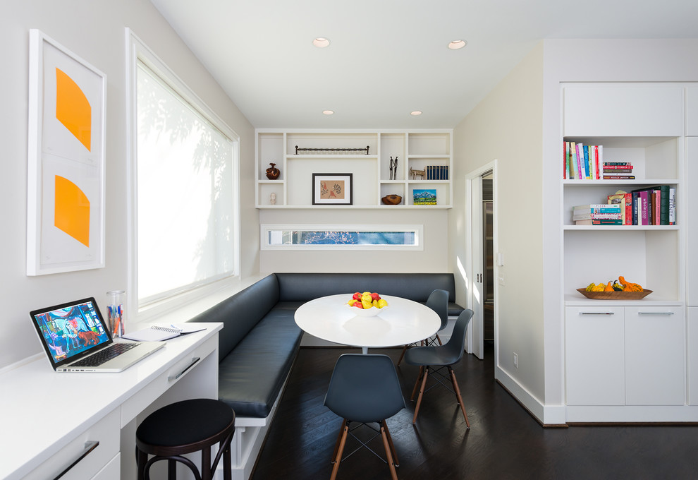 Immagine di una sala da pranzo aperta verso la cucina minimal con pareti bianche e parquet scuro