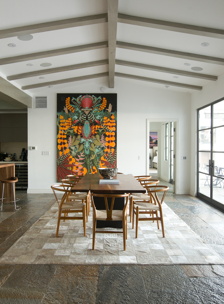 Immagine di una grande sala da pranzo aperta verso la cucina design con pareti bianche e pavimento in ardesia