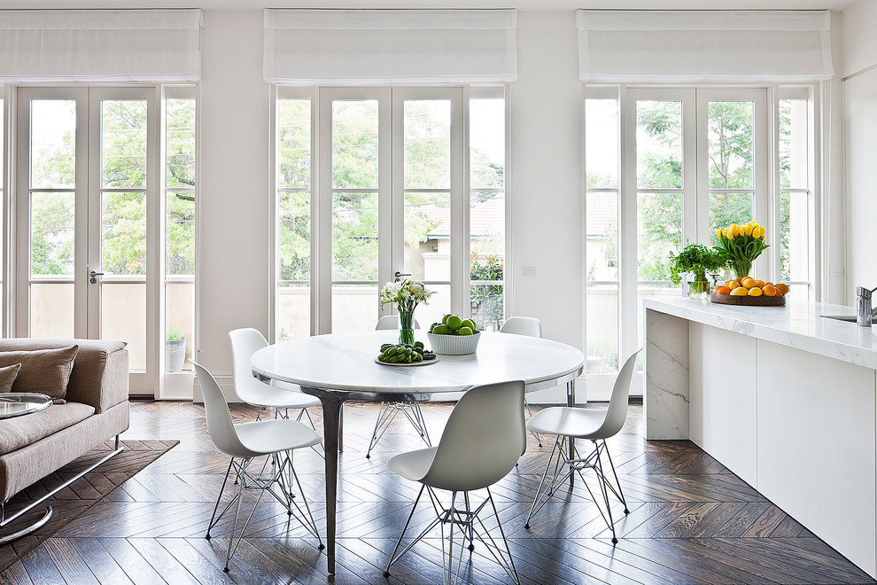Immagine di una sala da pranzo aperta verso il soggiorno design con pareti bianche