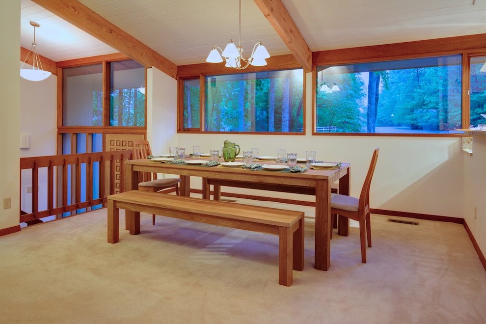 Cette image montre une salle à manger design avec un mur blanc et moquette.