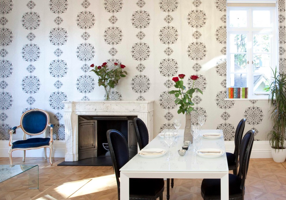 Dining room - contemporary medium tone wood floor dining room idea in London with a standard fireplace