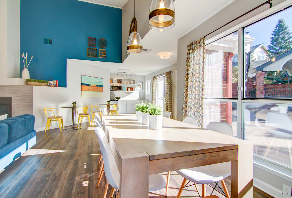 Inspiration for a contemporary open plan dining room in Denver with blue walls and light hardwood flooring.