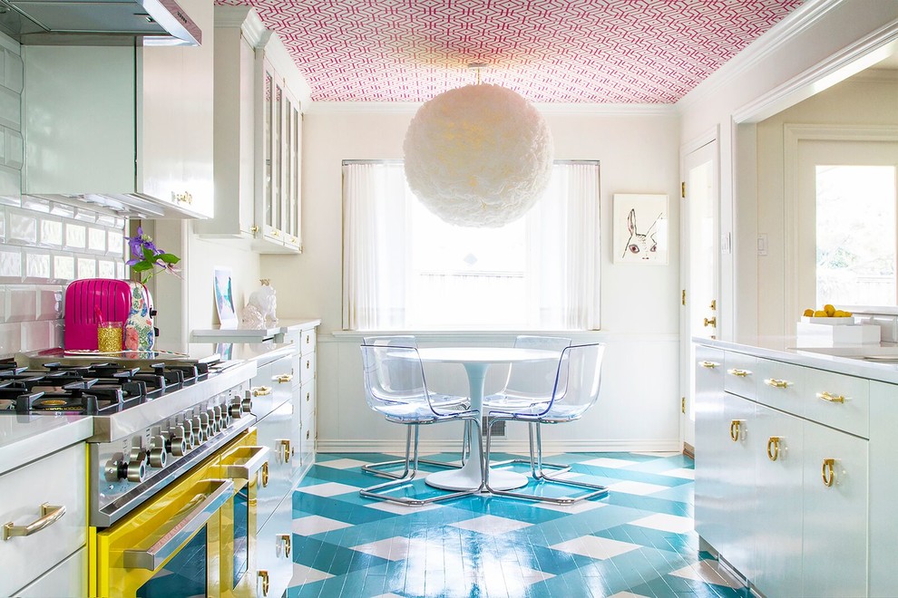 Cette image montre une salle à manger ouverte sur la cuisine design avec parquet peint, un mur blanc et un sol bleu.