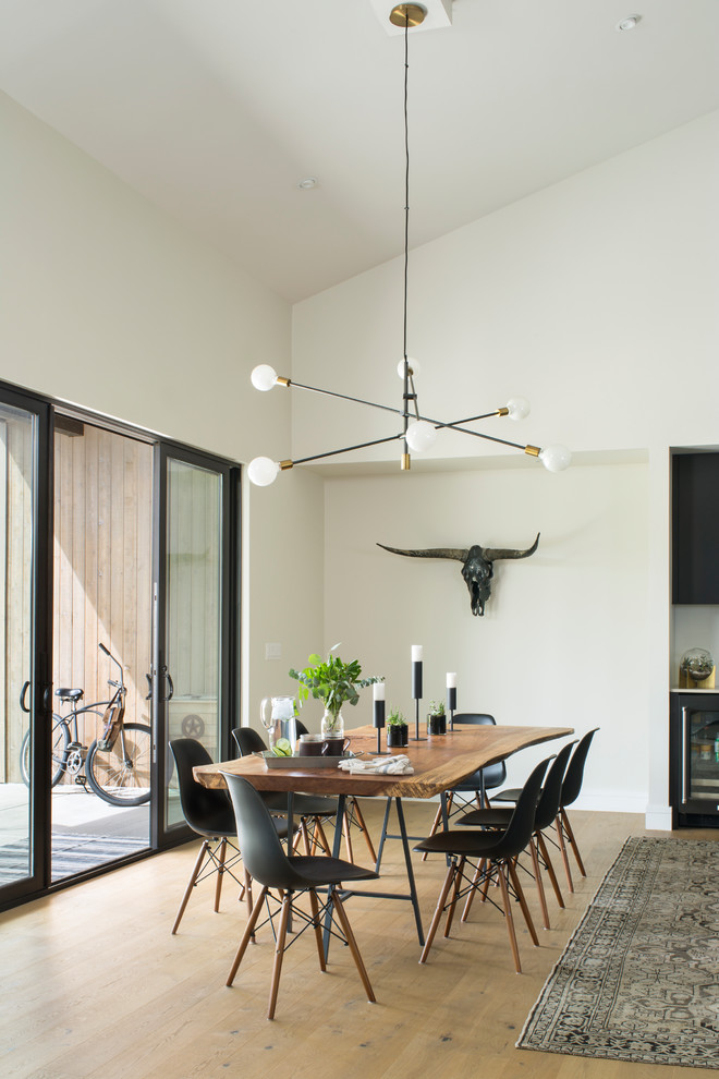 Exemple d'une salle à manger tendance avec un mur blanc, un sol en bois brun et un sol marron.