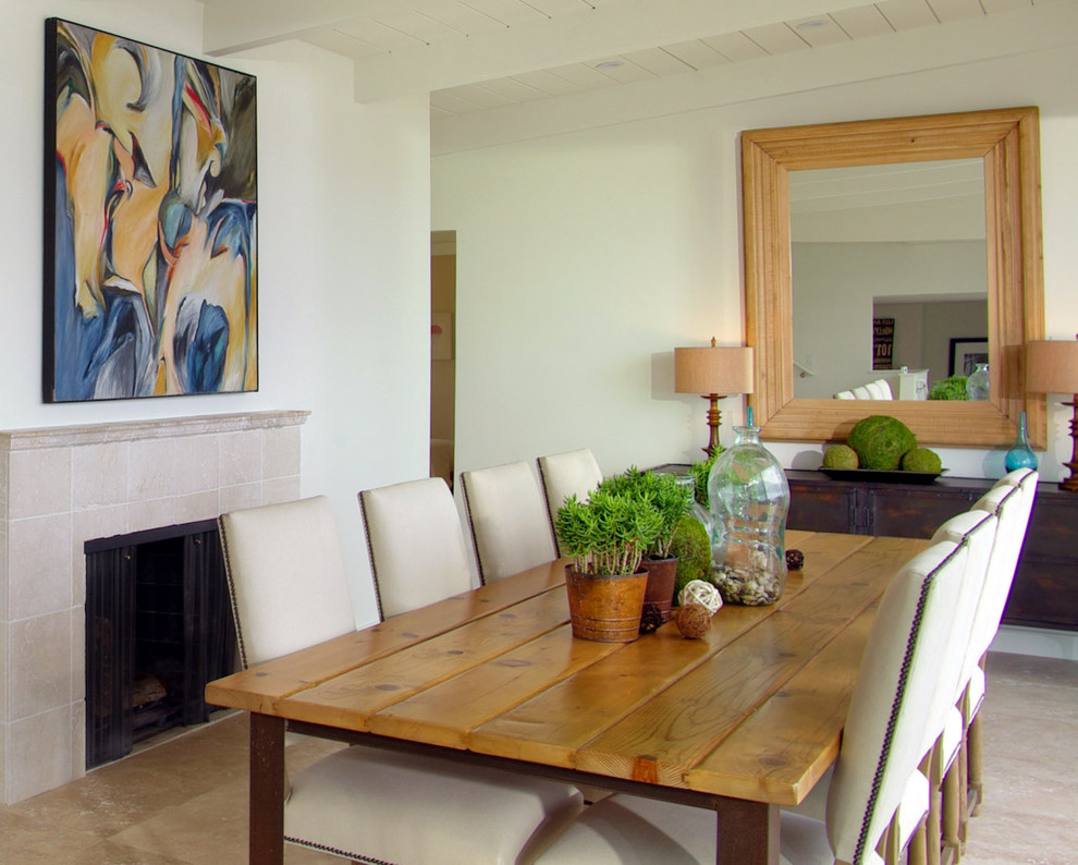 This is an example of a nautical dining room in San Francisco with white walls and a standard fireplace.