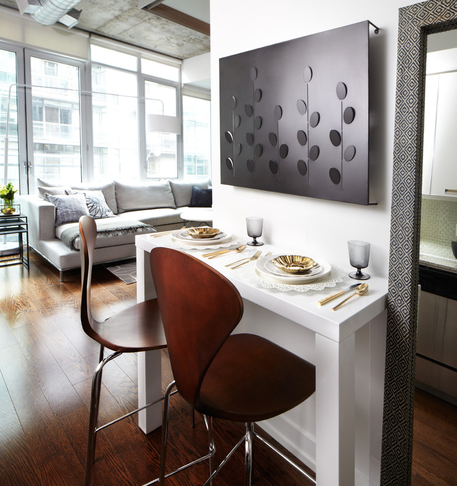 Cette image montre une salle à manger design avec un mur blanc, parquet foncé et éclairage.