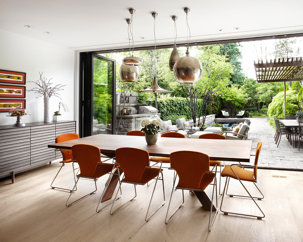 Inspiration for a contemporary dining room in Toronto with light hardwood flooring.