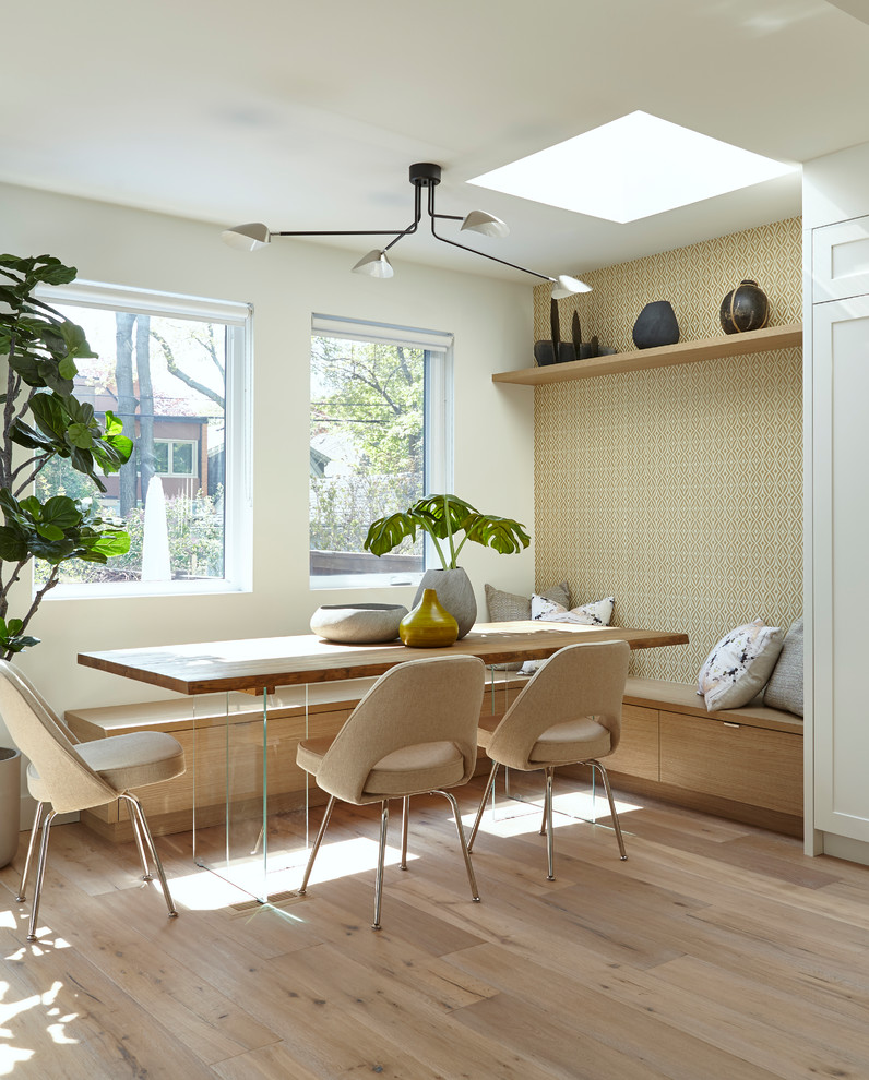 Cette photo montre une salle à manger tendance avec un mur blanc, un sol en bois brun et un sol marron.