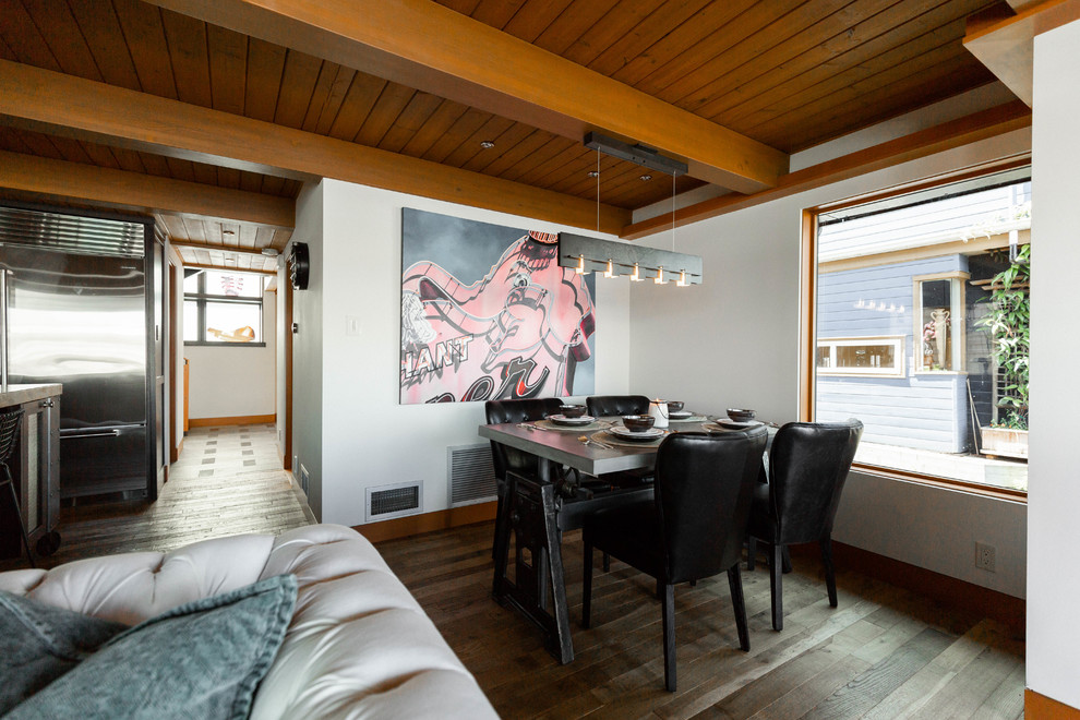 Réalisation d'une petite salle à manger design avec un sol en bois brun, un mur blanc et un sol marron.