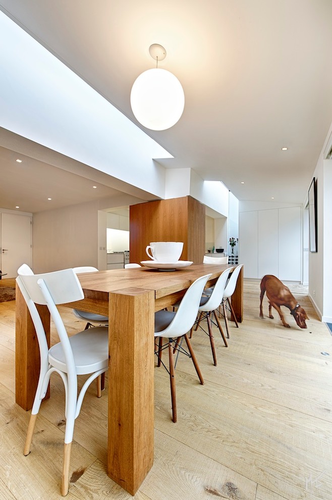 Пример оригинального дизайна: большая кухня-столовая в современном стиле с светлым паркетным полом и белыми стенами