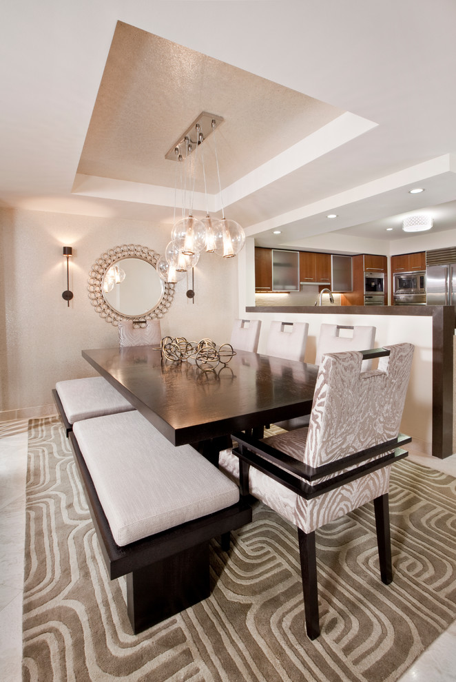 Cette photo montre une salle à manger ouverte sur la cuisine tendance avec un mur beige et éclairage.