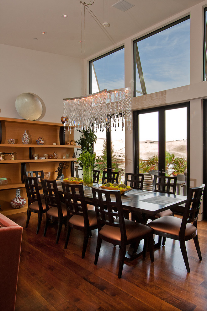 Inspiration pour une salle à manger design avec un mur blanc et parquet foncé.