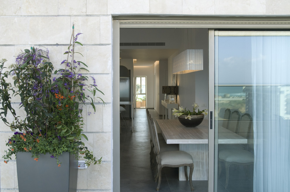 Immagine di una sala da pranzo aperta verso il soggiorno design con pavimento in cemento
