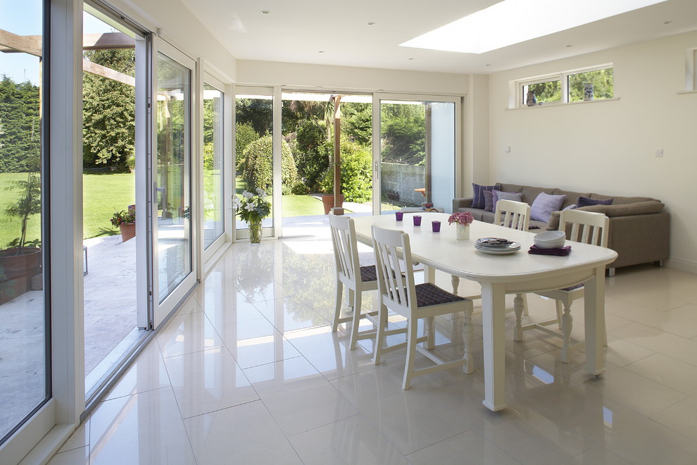 Design ideas for a contemporary dining room in Dublin with white walls, ceramic flooring and white floors.