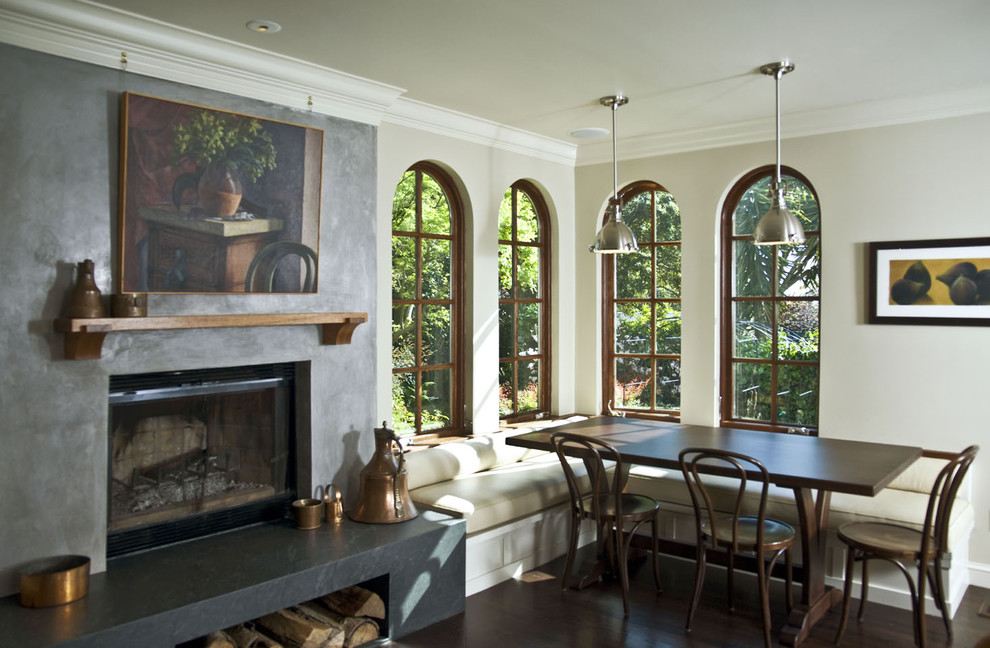 Exemple d'une salle à manger tendance avec un mur beige, parquet foncé et une cheminée standard.