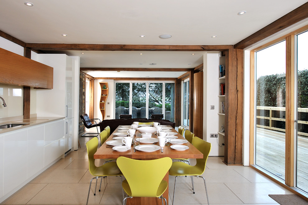 Immagine di una sala da pranzo aperta verso il soggiorno minimal con pareti bianche e pavimento beige