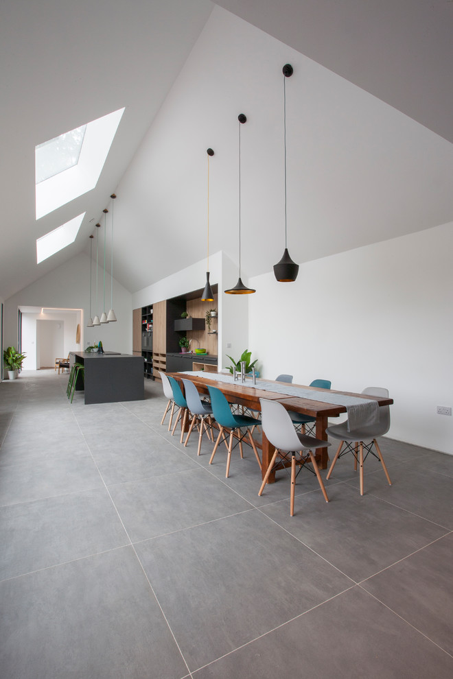 Ispirazione per una sala da pranzo aperta verso la cucina design con pareti bianche e pavimento grigio