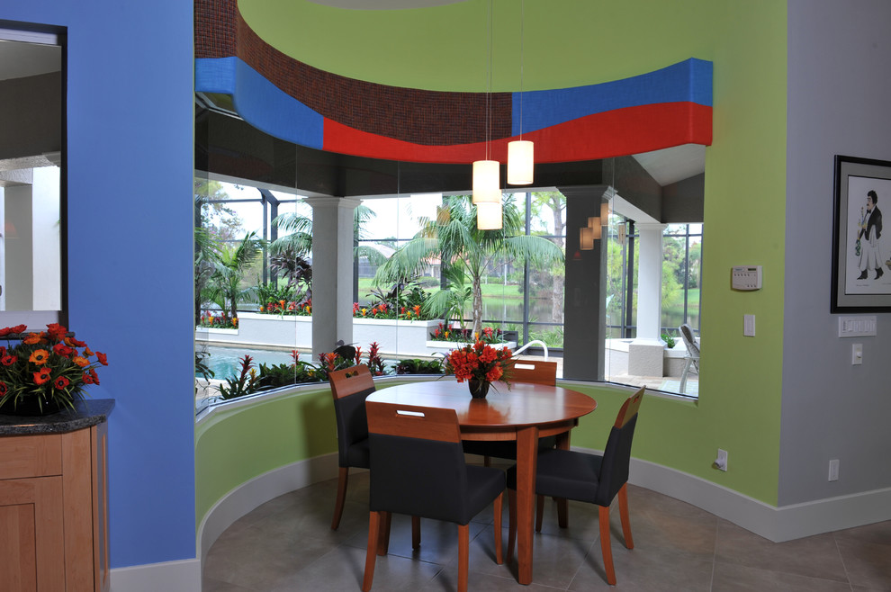Cette image montre une salle à manger design avec un mur vert, un sol en carrelage de porcelaine et un sol beige.