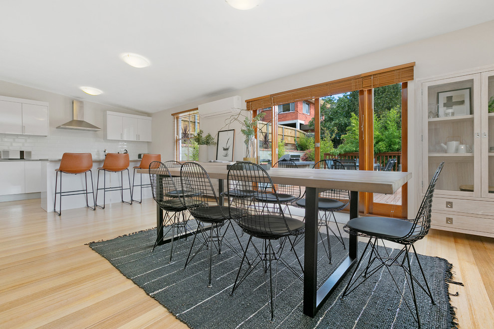 Ispirazione per una sala da pranzo aperta verso il soggiorno minimal con pareti beige e parquet chiaro