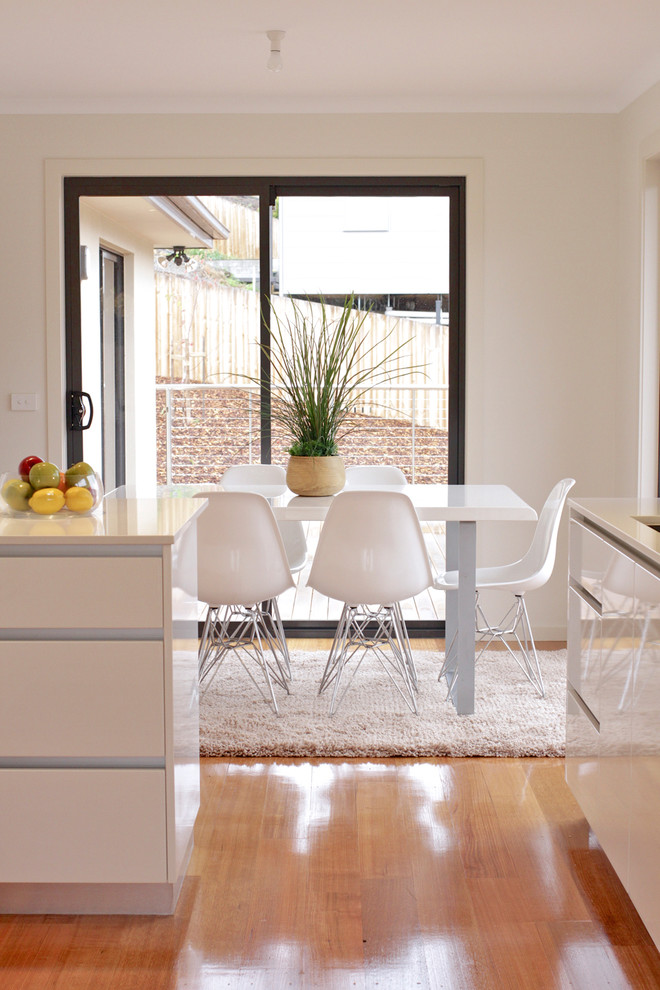 Moderne Wohnküche mit weißer Wandfarbe und braunem Holzboden in Hobart