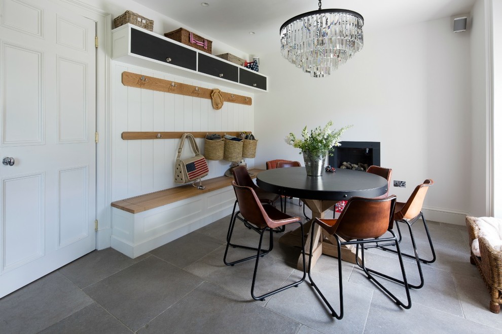 Immagine di una sala da pranzo minimal di medie dimensioni con pareti bianche, stufa a legna e pavimento grigio