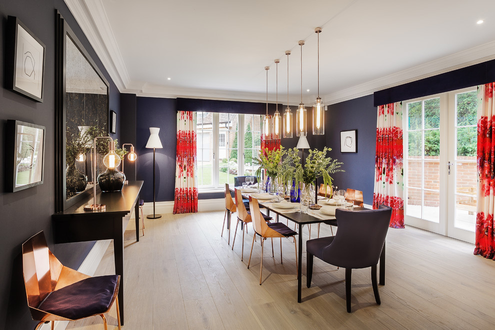 This is an example of a large contemporary enclosed dining room in Hampshire with blue walls, light hardwood flooring, no fireplace and feature lighting.